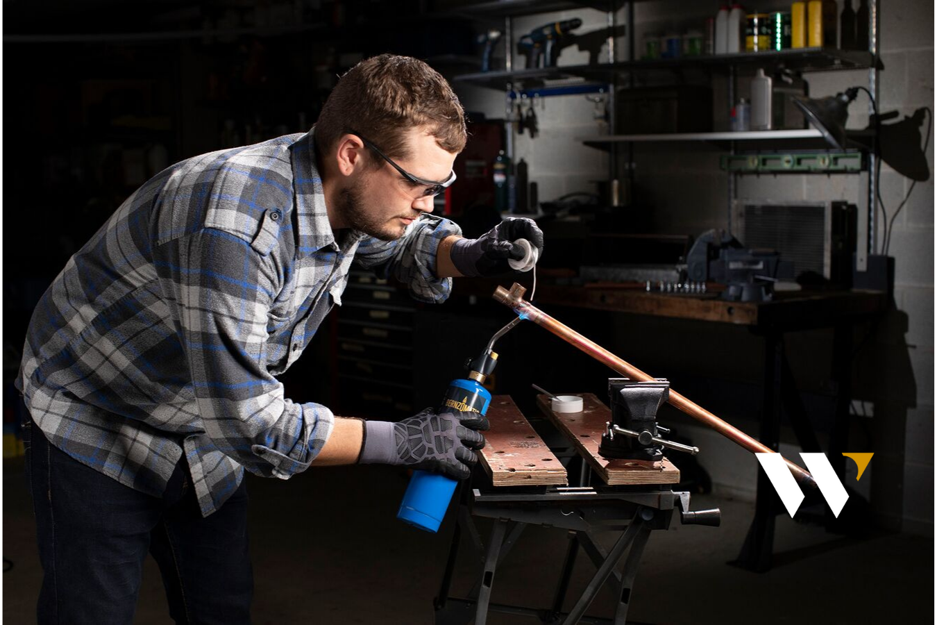 Man soldering copper with propane torch