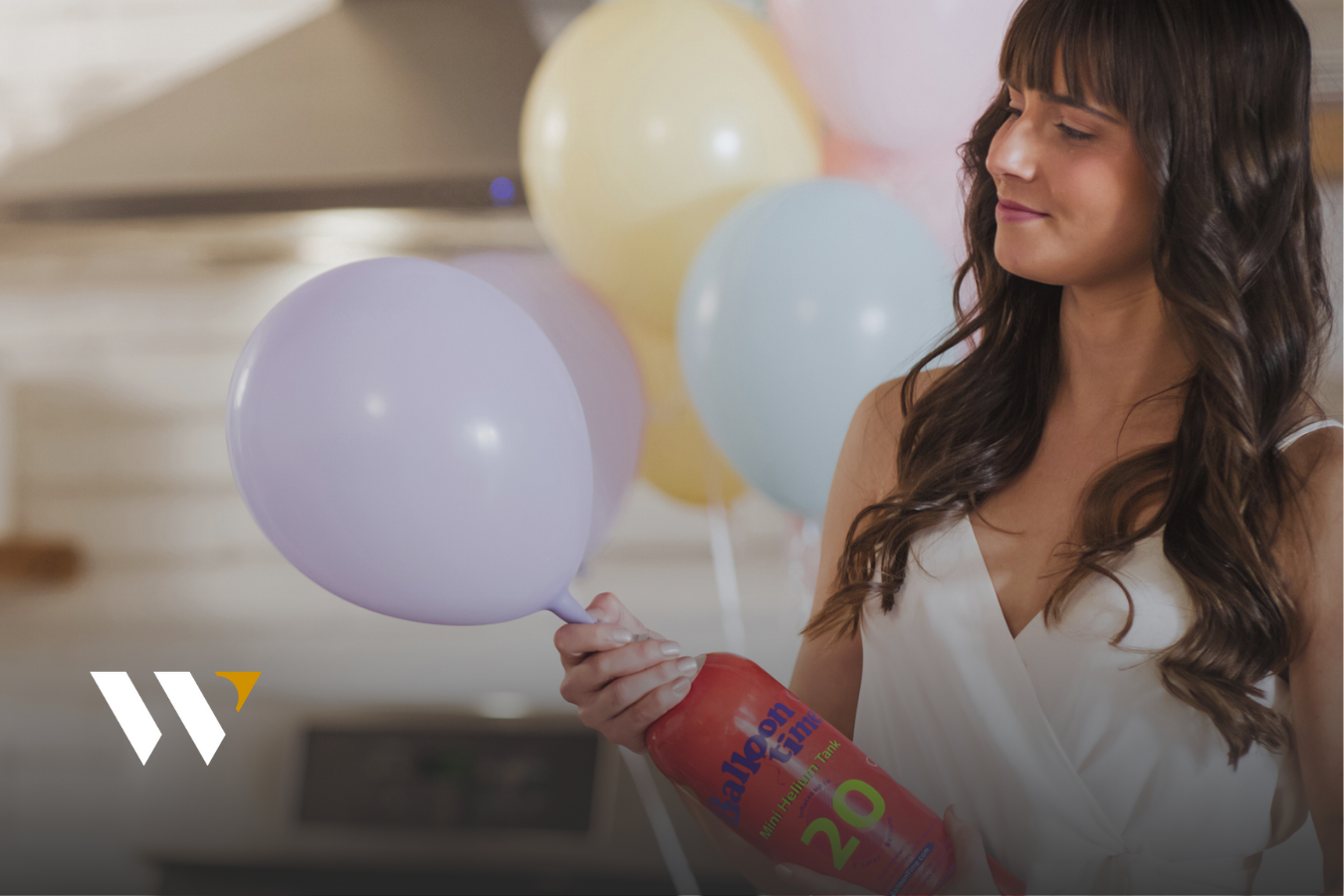 Woman filling balloon with mini helium tank